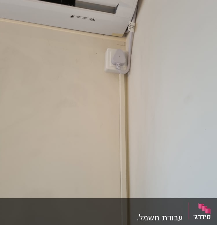 יחידת מיזוג אוויר עם חיבור חשמלי על הקיר